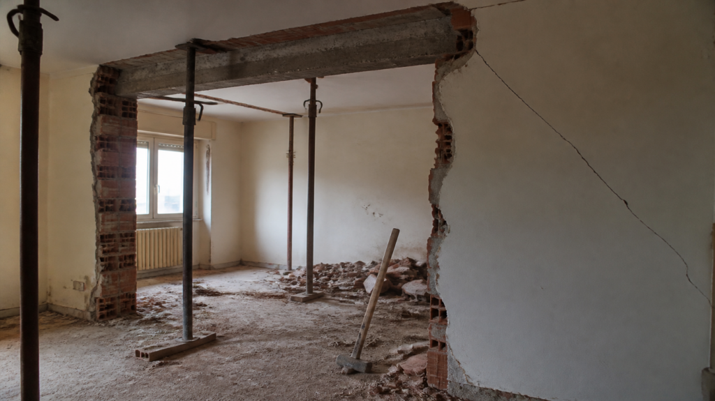 Lavori per abbattere un muro in casa con puntelli sotto il solaio e crepa sul muro
