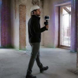 Ingegnere che esegue il rilievo di un edificio anni Settanta con un laser scanner SLAM portatile
